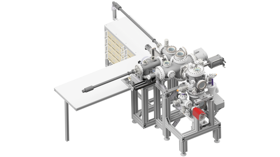 The image shows a computer model of an ultra-high vacuum system for measuring outgassing rates. The system consists of various bolted vacuum chambers, flanges, and windows. Linear actuators for inserting and moving samples within the vacuum system can also be seen. Next to the vacuum apparatus is a desk workstation.