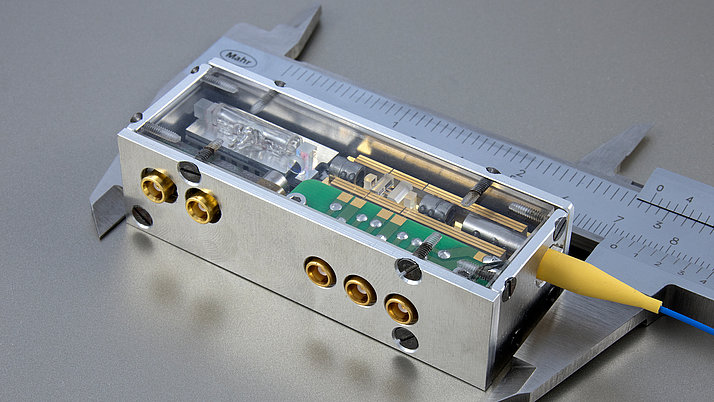 Electrical device in a transparent housing with several connections. A circuit board is visible, as well as various mechanical parts and screws.