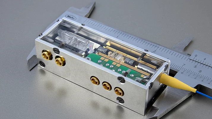 Electrical device in a transparent housing with several connections. A circuit board is visible, as well as various mechanical parts and screws.