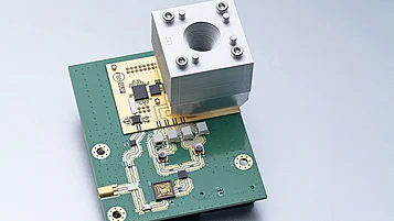 Modular MIMO millimeter-wave radar for space applications: Circuit board with electronic components and mounted transmitter module (upconverter) with corrugated horn antenna.