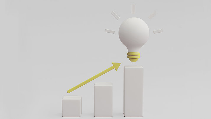 A diagram shows three ascending columns in white. A light bulb-like figure hovers above the columns, emitting rays of light, accompanied by an arrow pointing upwards.