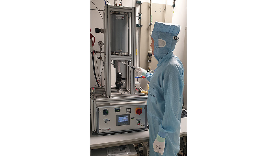 Person in front of oven for high-temperature annealing located in FBH’s epitaxy cleanroom.