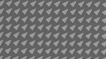 Microscopic image of a photonic crystal lattice with a repeating triangular pattern on a semiconductor surface.