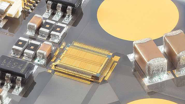 Close-up of a circuit board with various electronic components, including black and silver chips, gold connectors, and circular pads. The intricate layout highlights the details of the circuitry and the arrangement of components essential for electronic functionality.
