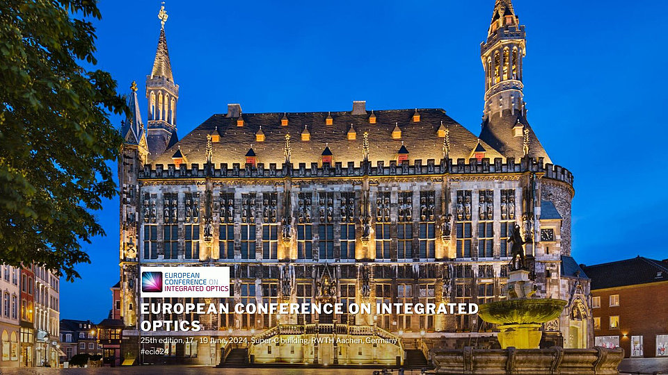  Ein historisches Gebäude in Aachen, beleuchtet in der Dämmerung. Es kündigt die 25. European Conference on Integrated Optics an, die vom 17. bis 19. Juni 2024 im Super-C Gebäude der RWTH Aachen stattfindet.