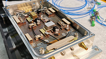 Open housing with electronic components. Inside are circuit boards, cables, switches and various components that are connected to each other.