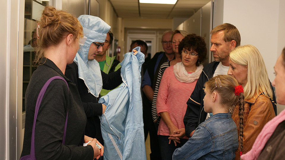 Führung bei Eltern auf Tour, bei denen Eltern und Kinder vor dem Reinraum stehen