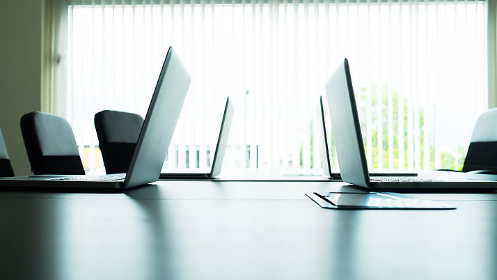 4 laptops on a conference table.