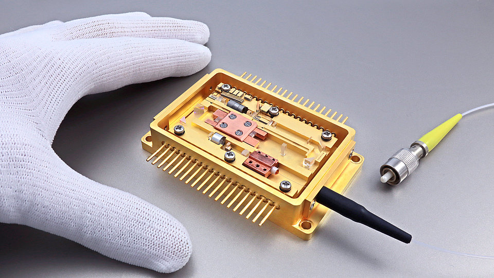 Yellow emitting laser module with fiber connection with one hand as size comparison