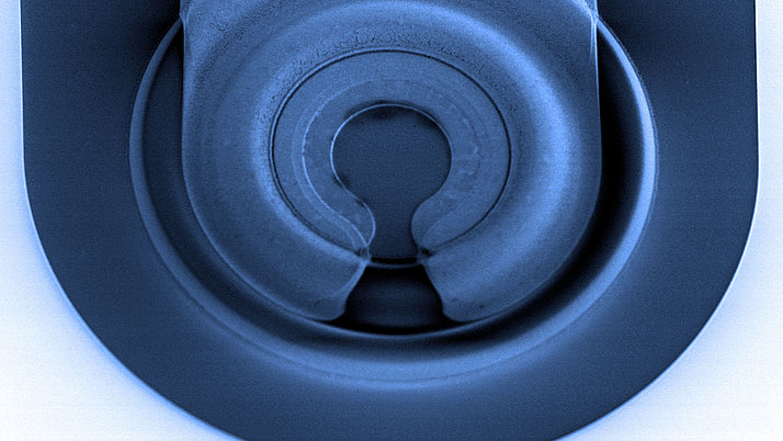 SEM image of a VCSEL (Vertical-Cavity Surface-Emitting Laser) structure, showing intricate circular layers and a precise, symmetric design for efficient optical performance.