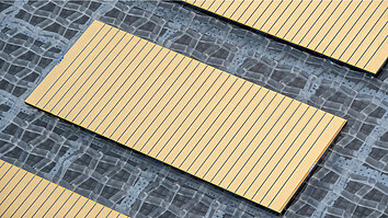 Nahaufnahme von drei goldfarbenen Diodenlaser-Barren mit feinen parallelen Streifen, diagonal auf einem grauen, gemusterten Substrat angeordnet.