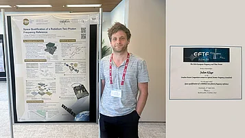 A scientist is standing in front of a research poster about a rubidium two-photon frequency reference. On the right is a certificate for the best student paper at a conference.