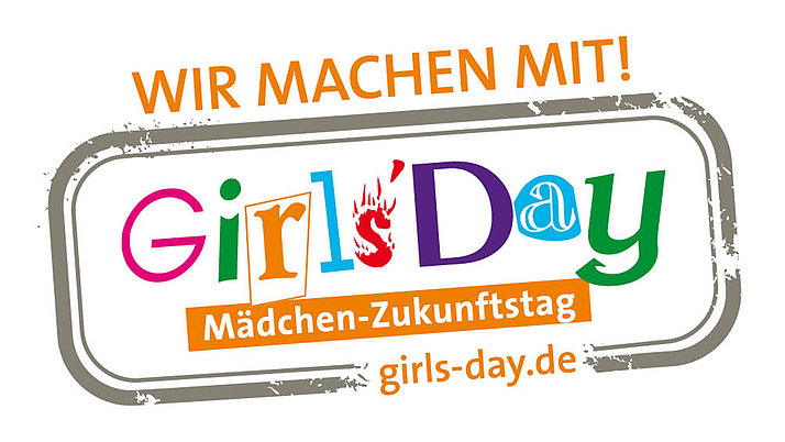 Logo für den "Girls' Day". Es zeigt den Text "Wir machen mit!" und "Mädchen-Zukunftstag" in bunten, stilisierten Buchstaben. Die Website-Adresse "girls-day.de" ist ebenfalls enthalten.