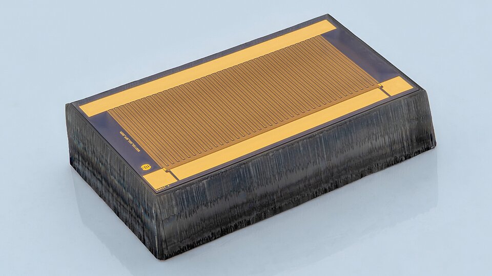 Gallium oxide MOSFET: The small semiconductor device looks like a rectangular, flat black box with a gold-colored top and a grooved surface.
