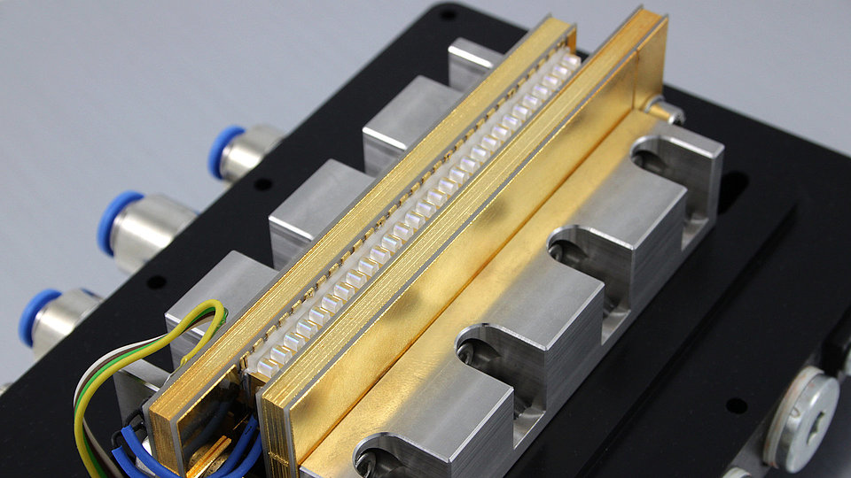 Hochleistungs-Laserstack mit Linsen, bei dem die Emission mehrerer Emitter zu einem Strahl gebündelt wird