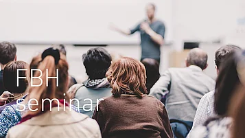 Publikum blickt auf einen unscharfen Vortragenden, der vorne in einem Raum spricht, mit eingeblendetem Text „FBH Seminar“.