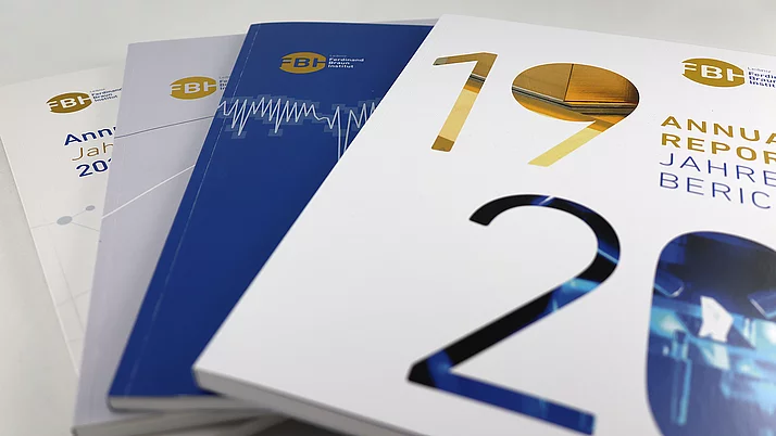 Drei Jahresberichte des Ferdinand-Braun-Instituts liegen übereinander. Die Cover zeigen verschiedene Farben und grafische Elemente.