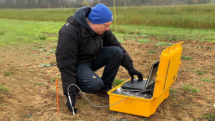 An FBH employee operates the portable SERDS sensor system in a field for a soil analysis.