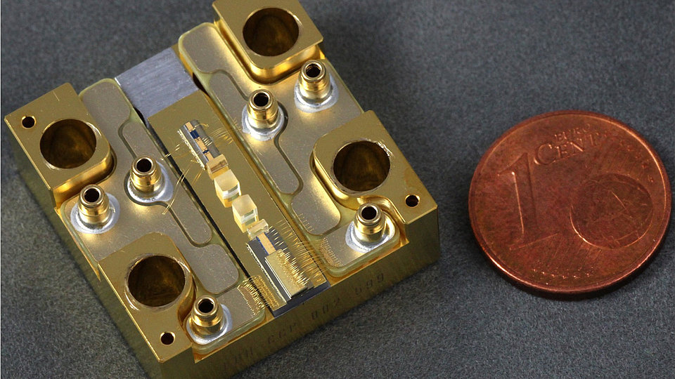 Sampled Grating MOPA Laserquelle neben einer 1 Cent Münze.